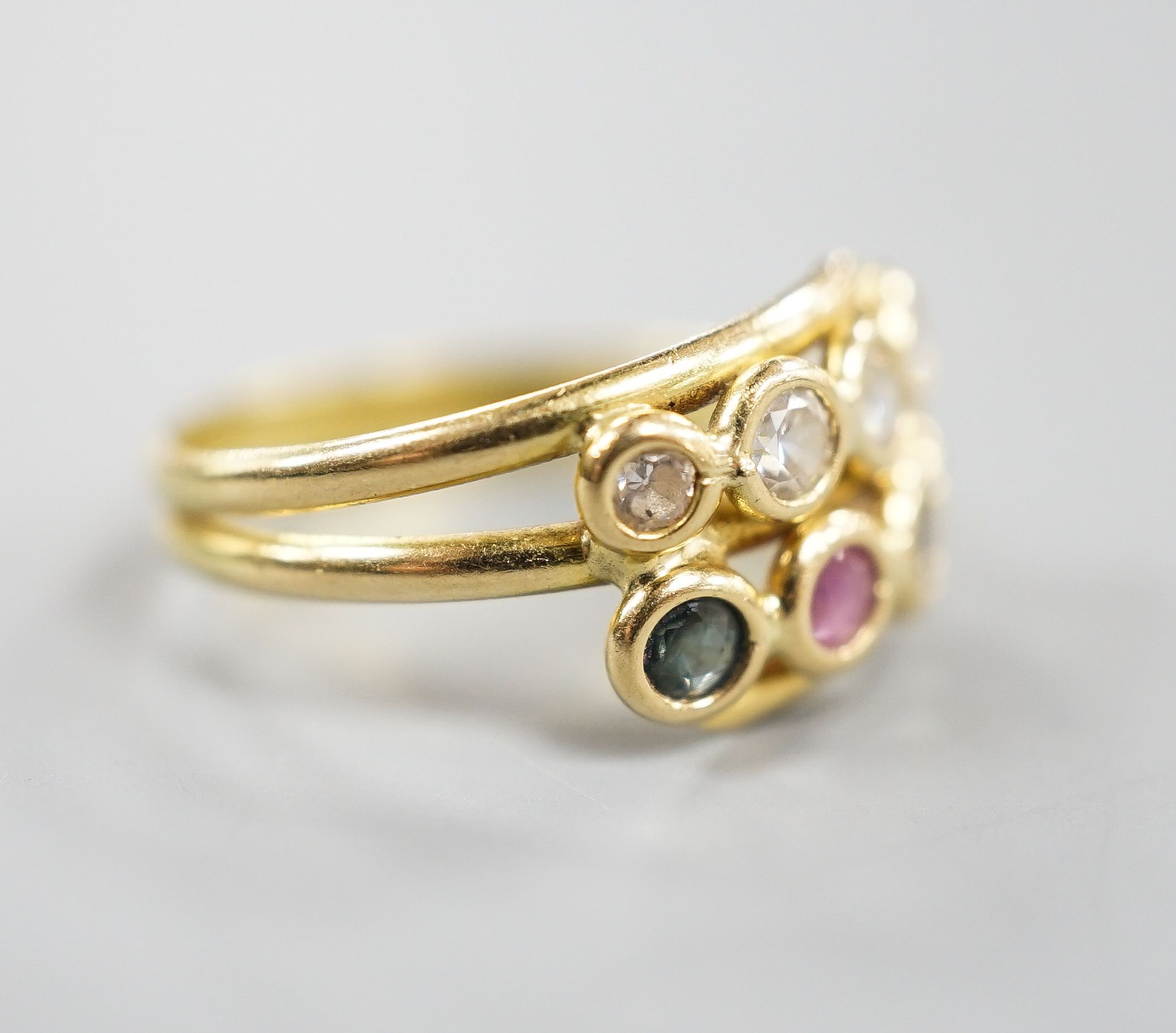A modern Italian 750 yellow metal and collet set four stone diamond, two stone sapphire and two stone ruby set two row ring, size J/K gross 2.8 grams.